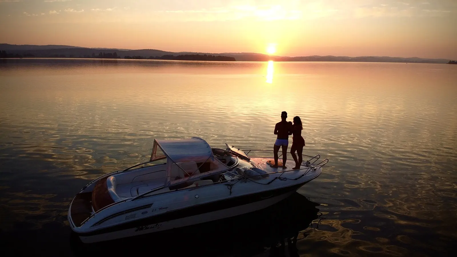 Paar auf einem Boot im Sonnenuntergang auf dem See